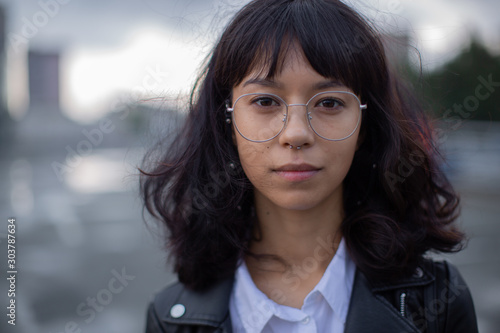 Asian teen girl's face in glasses.