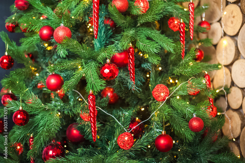 Background from a Christmas tree decorated in red and gold color close-up. Greeting card from a Christmas tree with red decorations and copy space. Details of a decorated Christmas tree with a frame f