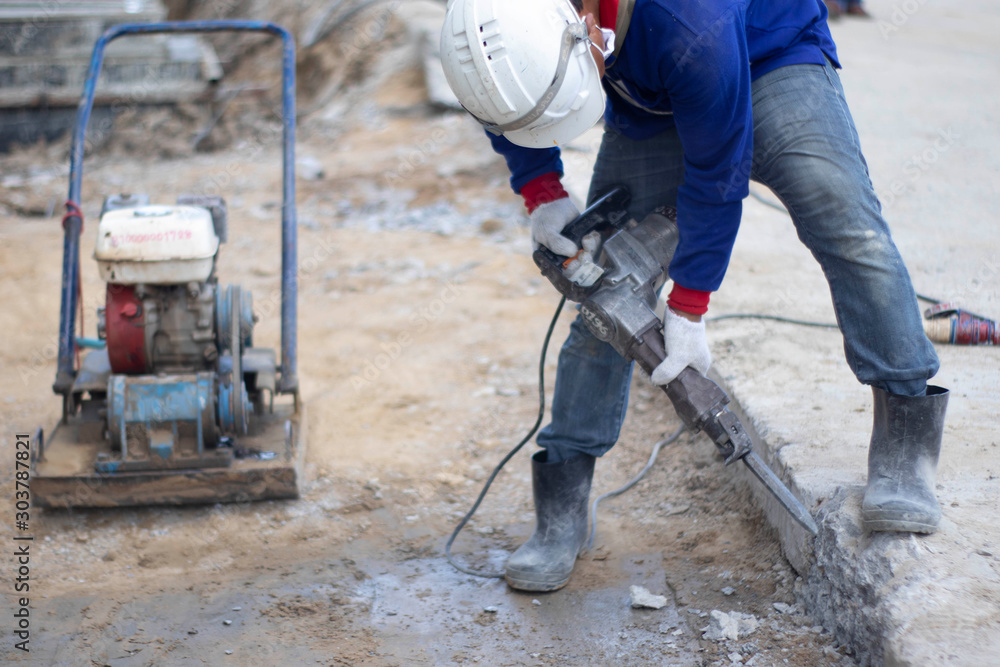 Workers are using the tools to extract the excess cement to the pattern. With white cloth gloves Blue shirt, jeans, small side plate in construction area Workers are using the tools to extract the excess cement to the pattern. With white cloth gloves Blue shirt, jeans, small side plate in construction area