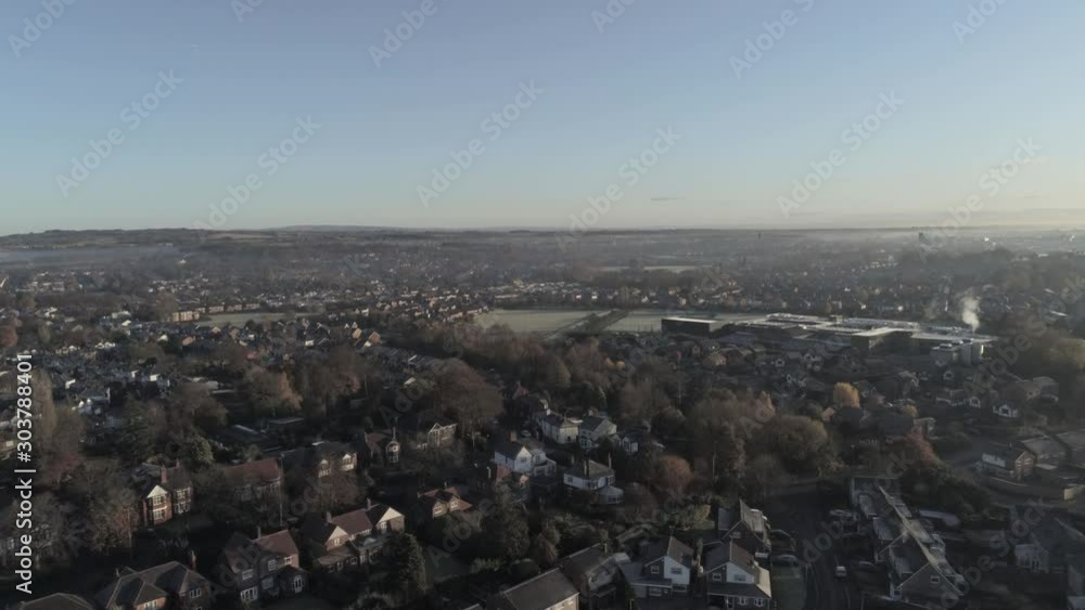 Aerial view above UK town, village rooftops Autumn frost scenic view. Ascending high view, tilt down.