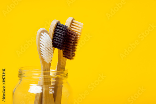 Set of four eco friendly bamboo toothbrushes on the orange background. Copy space. Zero waste concept  plastic-free  organic  eco-friendly shopping