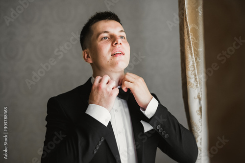 Grooms morning preparation. Handsome man getting dressed and preparing for the wedding photo