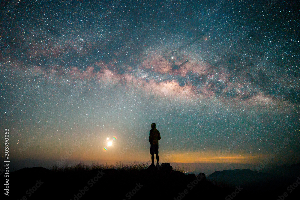 Fototapeta premium Landscape with Milky way, Milky way background, Night sky with stars and galaxy over night sky and silhouette of a standing people in Thailand