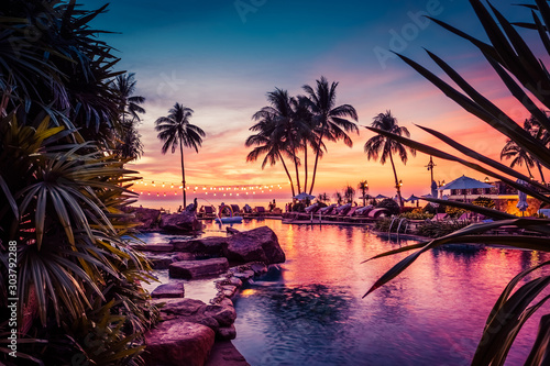 Stunning sunset view with palm trees reflecting in swimming pool in luxury island resort in Thailand © Mazur Travel