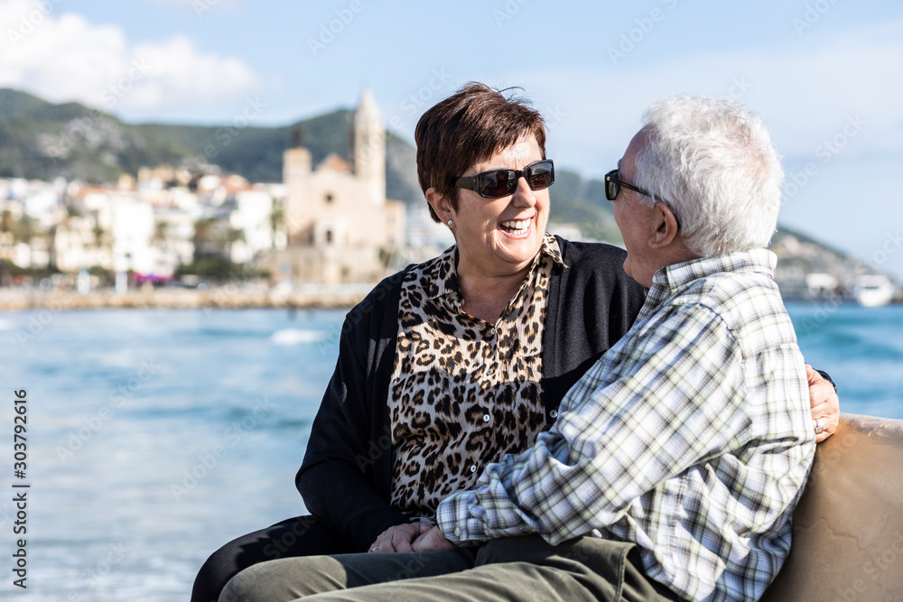 Two seniors sitting on a Sitges bench, in Spain