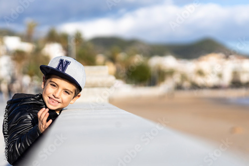 Little kid with cap in a stone railing © Victor