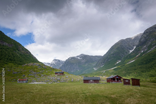 Norwegian old cabins in green mountain valley in glacier national park