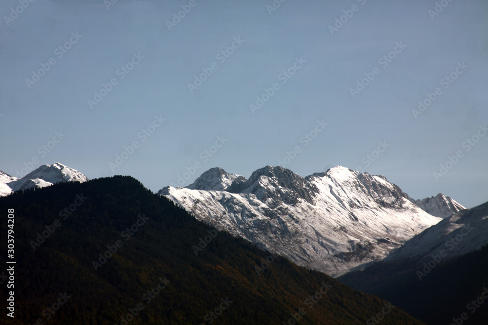 View over snow-covered mountain peak against blue sky
