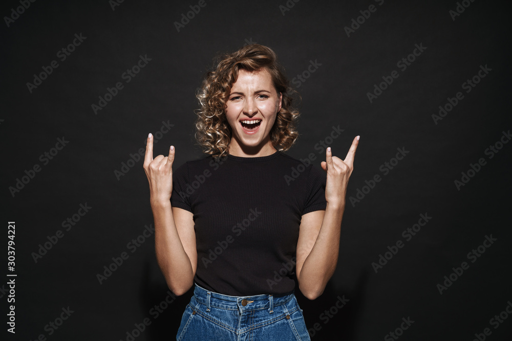 Happy cute young woman showing rock gesture. Happy cute young woman showing rock gesture.
