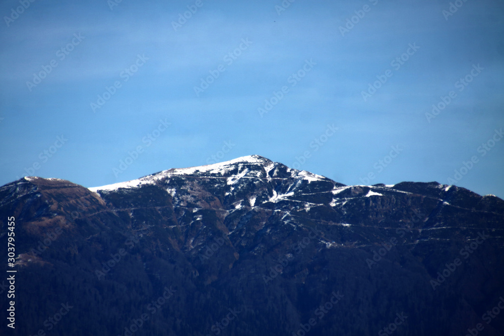 view over snow-covered mountain peak against bue sky