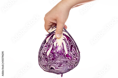 A hand holding a red cabbage.