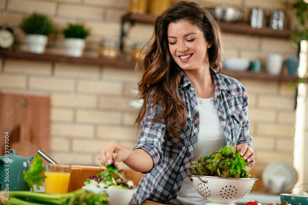 Young woman in kitchen. Beautiful woman making healthy food.