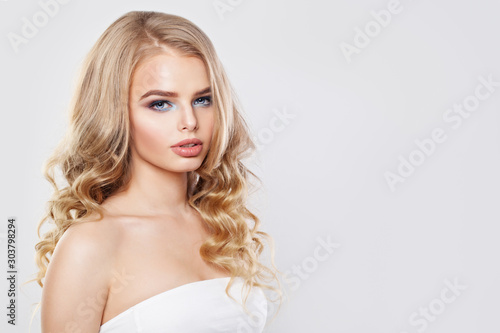 Beautiful model woman with long healthy curly hair on white background
