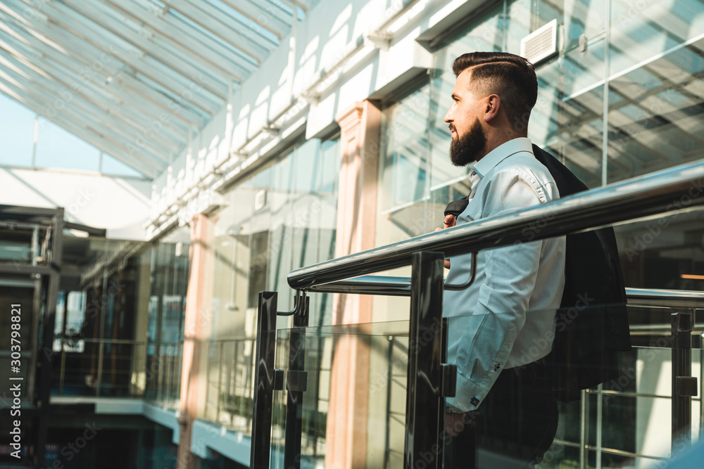 Portrait of a businessman in suit are standing on the background of glass offices. Portrait of a businessman in suit are standing on the background of glass offices.