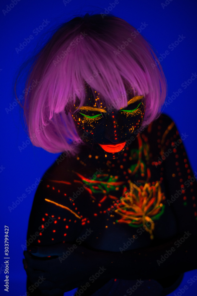 Portrait of Beautiful Fashion Woman in Neon UF Light. Model Girl with Fluorescent Creative Psychedelic MakeUp, Art Design of Female Disco Dancer Model in UV, Colorful Abstract Make-Up. Dancing Lady Portrait of Beautiful Fashion Woman in Neon UF Light. Model Girl with Fluorescent Creative Psychedelic MakeUp, Art Design of Female Disco Dancer Model in UV, Colorful Abstract Make-Up. Dancing Lady