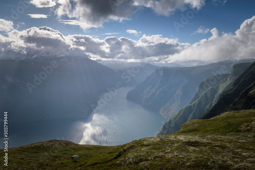 Sunburst with light beams lighting up fjord landscape Norway