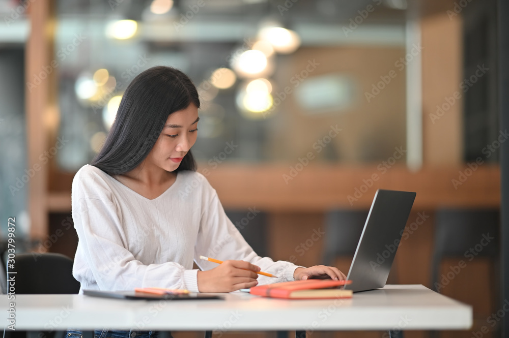 Young asian girl working at modern office and using laptop computer. Young asian girl working at modern office and using laptop computer.