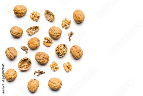 top view of walnuts closed and broken scattered on a white background with copy space
