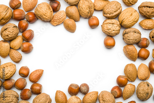 top view of mix of nuts scattered on white background with copy space