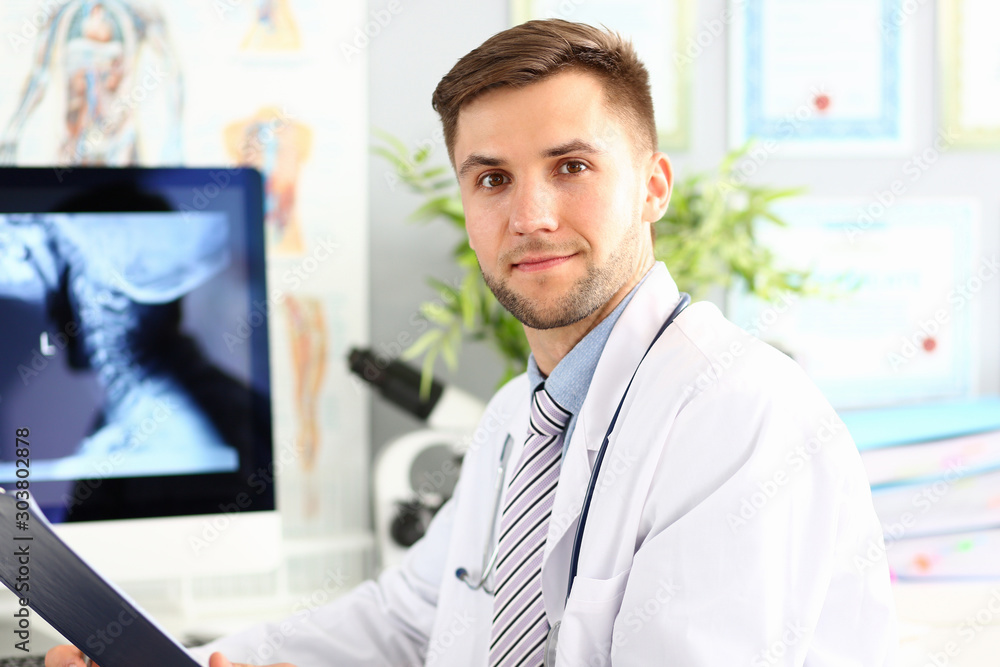 Smiling male doctor working with compute in his office Smiling male doctor working with compute in his office