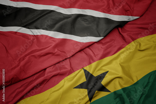 waving colorful flag of ghana and national flag of trinidad and tobago.