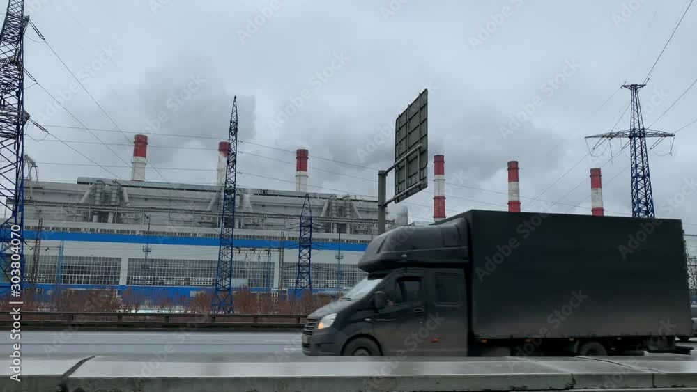 Factory with smoking chimneys near a highway in city limits. Close-up Factory with smoking chimneys near a highway in city limits. Close-up