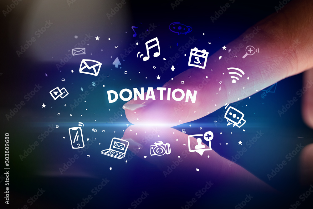 Finger touching tablet with drawn social media icons and DONATION inscription, social networking concept Finger touching tablet with drawn social media icons and DONATION inscription, social networking concept