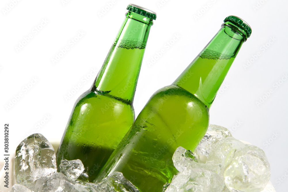 Two beer bottles getting cool in ice cubes