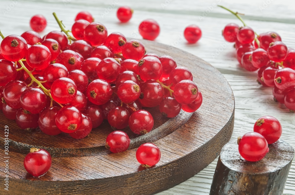 Red fruit in the kitchen. Red currant on a white wooden table. Red fruit in the kitchen. Red currant on a white wooden table.