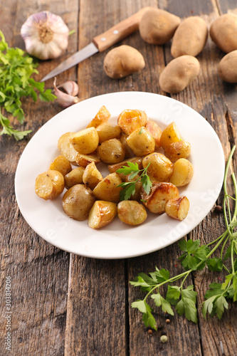 grilled potato with herb on wood background, top view