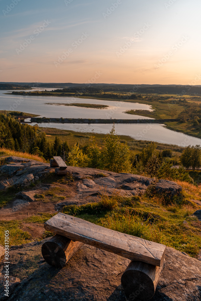 Bench with mountain views of the coniferous forest and lake. Sunset on Mount Paaso. Karelia Bench with mountain views of the coniferous forest and lake. Sunset on Mount Paaso. Karelia