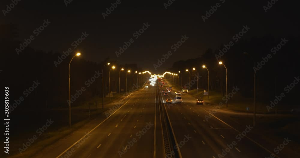Night highway with moving cars traffic slow motion view from above road. Aerial view of busy evening carriageway with tracks lorry driving into distance. Transportation trucking industry logistics Night highway with moving cars traffic slow motion view from above road. Aerial view of busy evening carriageway with tracks lorry driving into distance. Transportation trucking industry logistics