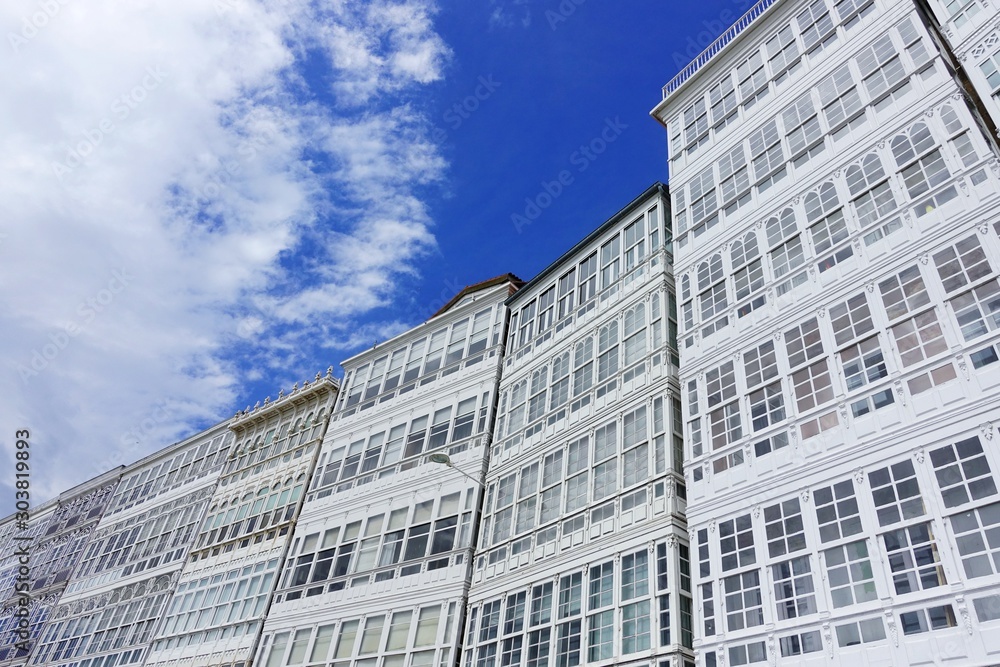 White facades of houses with glazed balconies