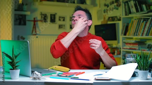 An office worker at the table is doing facial massage. photo