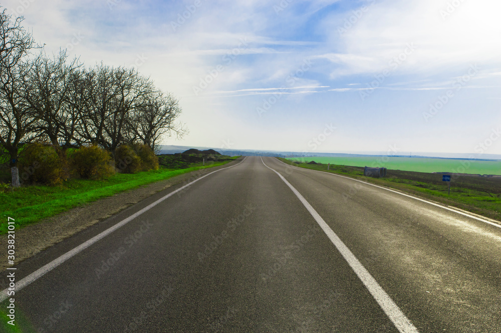 Highway outside the city among the hills against the blue sky. Highway outside the city among the hills against the blue sky.