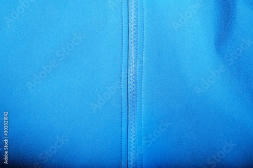 Detailed view of softshell jacket with water drops, zipper and seams. blue background photo