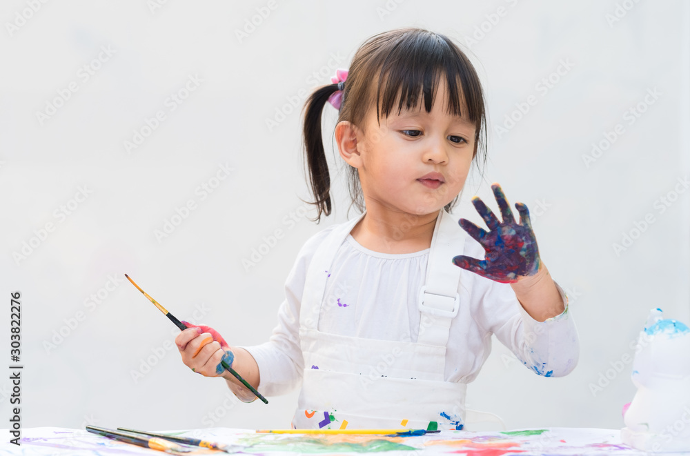 Φωτογραφία Cute asian little girl  is holding the brush for painting the color on hands , concept of art and education for kid