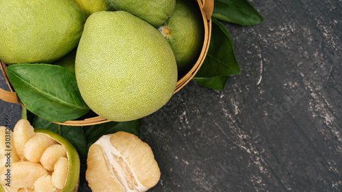 Konstfotografi Fresh peeled pomelo, pummelo, grapefruit, shaddock on dark background in bamboo basket