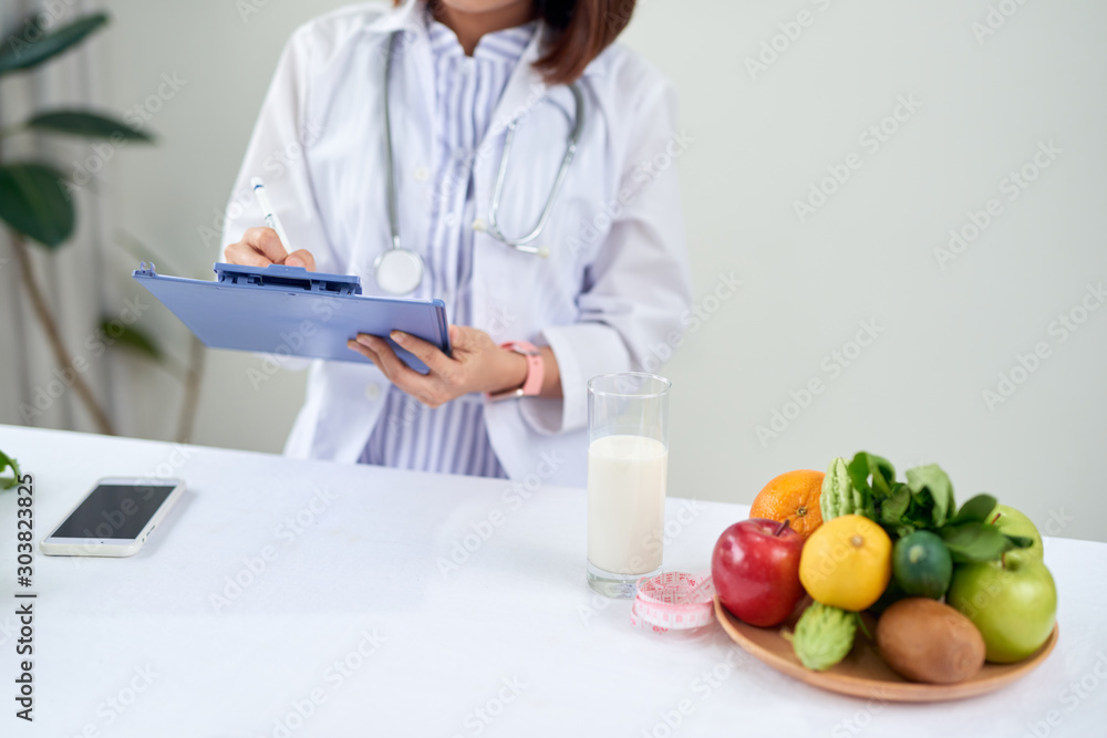 Female nutritionist with fruits working at her desk Female nutritionist with fruits working at her desk