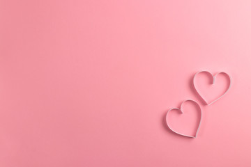 Composition for Valentine's Day February 14th. Delicate pink background and pink hearts cut out of paper. Greeting card. Flat lay, top view, copy space.
