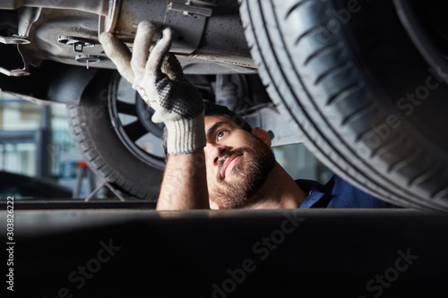 Mechatroniker bei der Reparatur von Auto Auspuff photo
