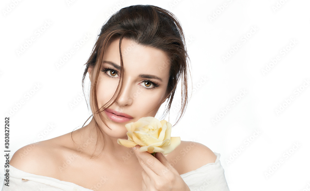 Gorgeous black haired female with healthy fresh skin and rose near face Gorgeous black haired female with healthy fresh skin and rose near face