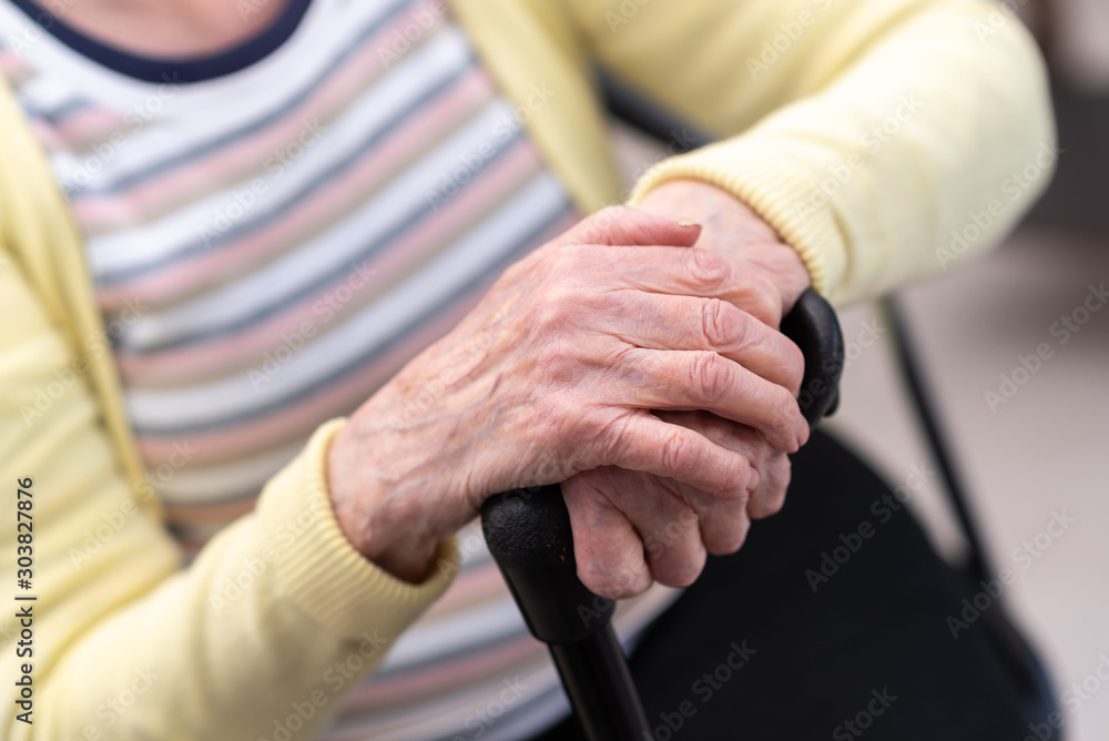 Old woman with her hands on a cane Old woman with her hands on a cane