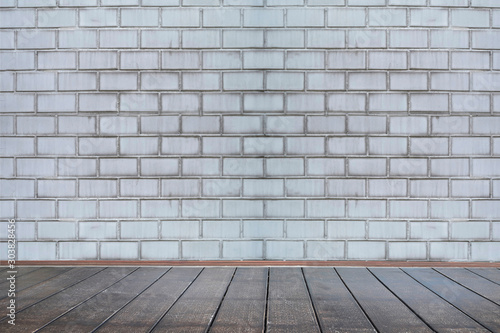 Background of aged grungy textured white brick and stone wall with light wooden floor with whiteboard inside old
