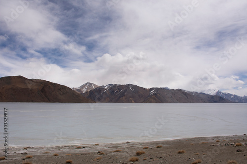 View landscape with Himalayas mountains and Pangong Tso high grassland lake while winter season for indian and tibetan and foreigner travelers travel visit at Leh Ladakh in Jammu and Kashmir, India