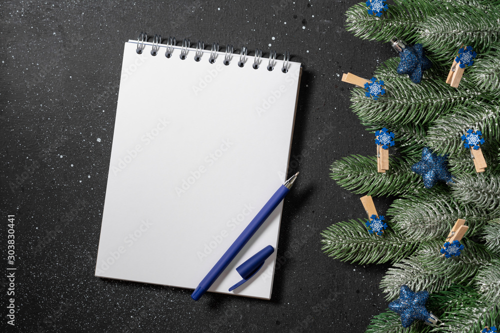 Christmas or New year holiday background with open blank Notepad, fir branches and Christmas traditional decorations. Top view with copy space Christmas or New year holiday background with open blank Notepad, fir branches and Christmas traditional decorations. Top view with copy space