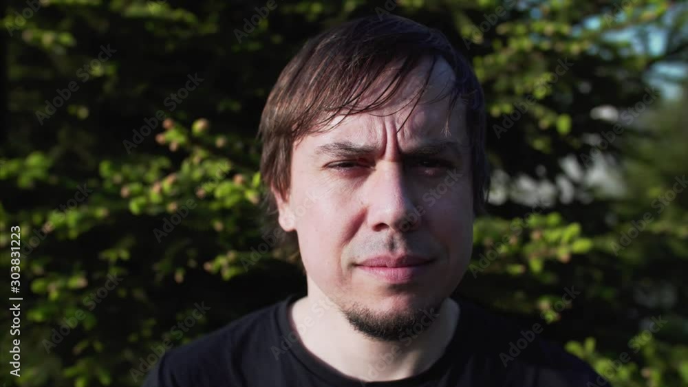 Portrait of young man looking into the camera and talking with someone behind it Portrait of young man looking into the camera and talking with someone behind it