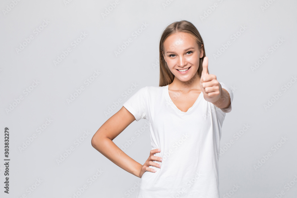 Young casual woman smiling with her thumbs up isolated on white background Young casual woman smiling with her thumbs up isolated on white background