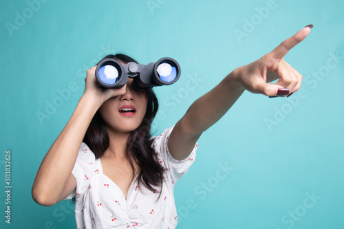 Young Asian woman  point and look with binoculars