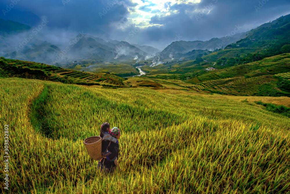 Φωτογραφία Vietnamese grandmother and young niece walking in the rice terraces to go to work in the morning of the harvest season in Mu cang chai,Yenbai,Vietnam